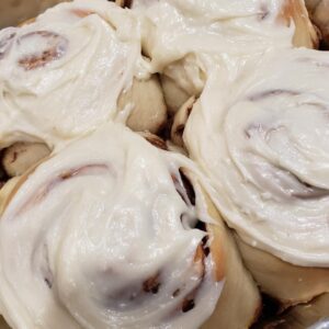 A close up of some cinnamon rolls covered in icing