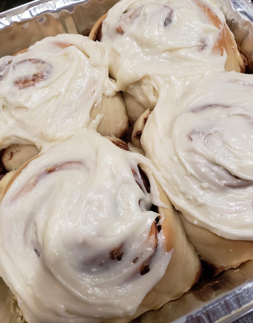 A close up of some cinnamon rolls covered in icing