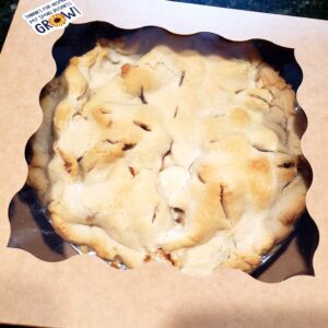 A pie in a box sitting on top of the table.