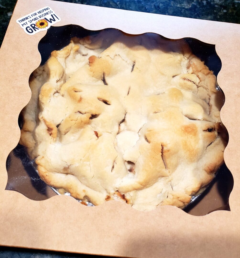 A pie in a box sitting on top of the table.